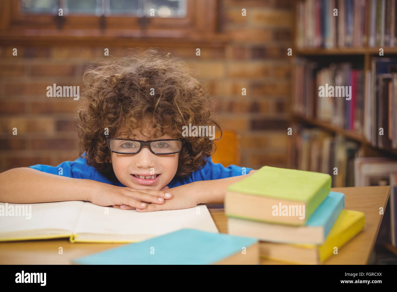 Cute pupil leaning on books in the library Stock Photo - Alamy