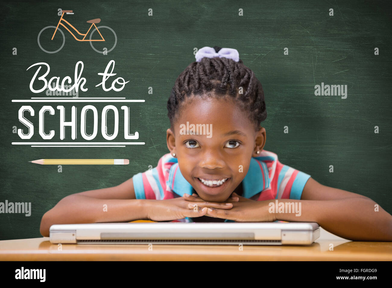 Composite image of smiling pupil sitting at her desk Stock Photo - Alamy