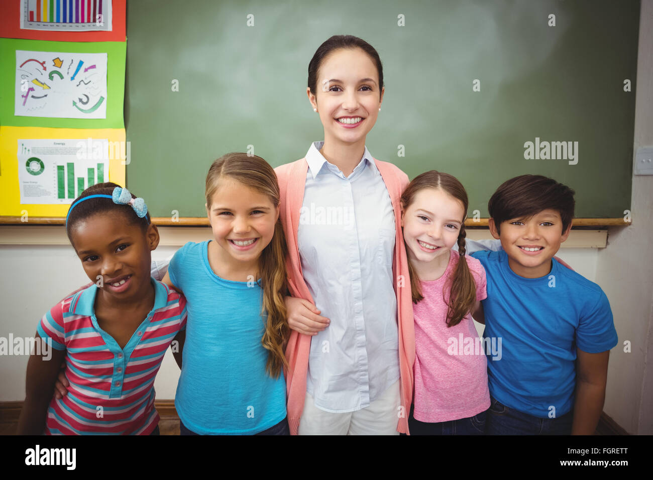 Teacher and pupils smiling in classroom Stock Photo - Alamy