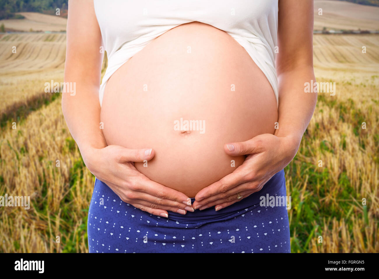 Composite image of pregnant woman holding her bump Stock Photo