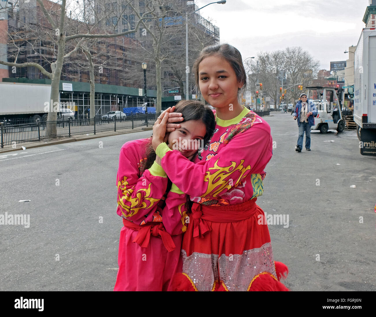 A girl holding her ears during a noisy Chinese New Years Parade on Allen Street in Chinatown, lower Manhattan, New York City Stock Photo