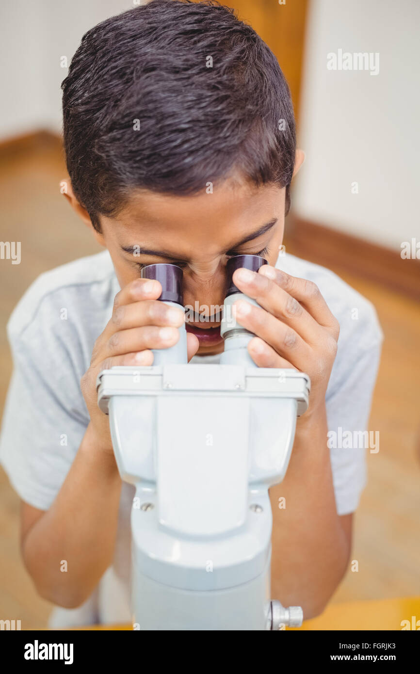 Pupil looking through microscope in class Stock Photo Alamy