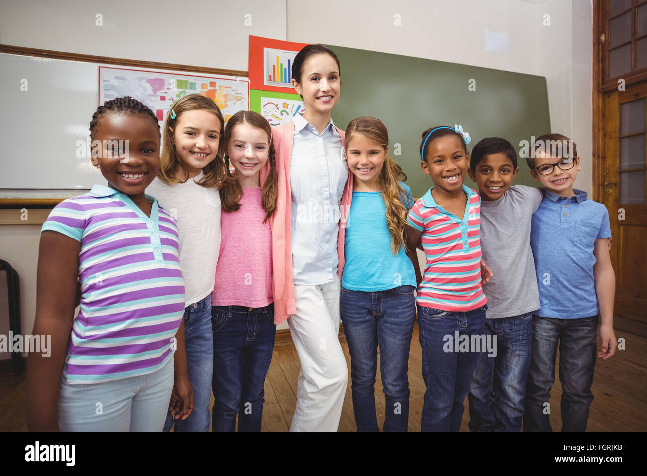 Teacher and pupils smiling in classroom Stock Photo - Alamy