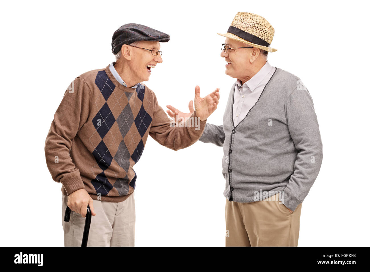 Two senior gentlemen talking to each other and laughing isolated on white background Stock Photo