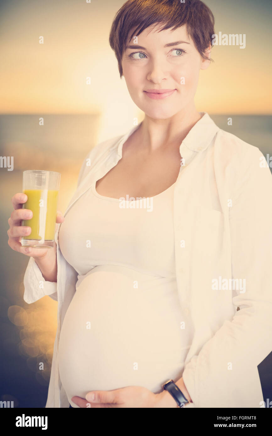 Composite image of pregnant woman holding glass of orange juice Stock ...