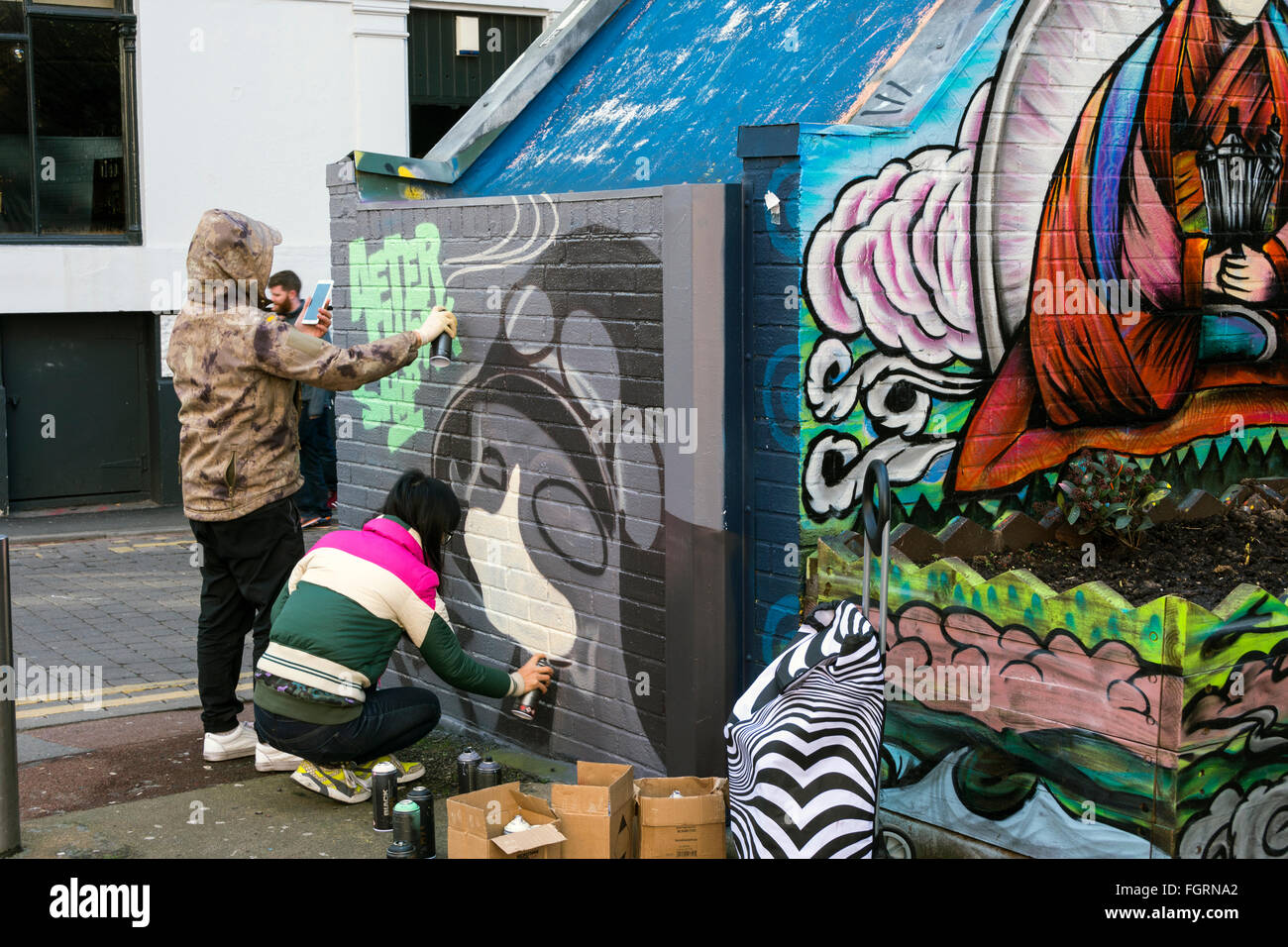 Street artists painting a mural at Tib Street, Northern Quarter, Manchester, England, UK Stock Photo
