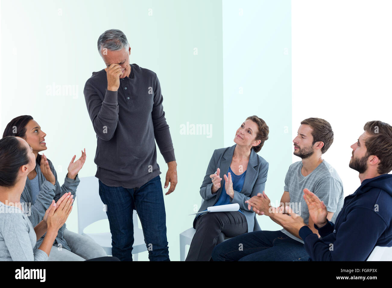 Composite image of rehab group applauding delighted man standing up Stock Photo