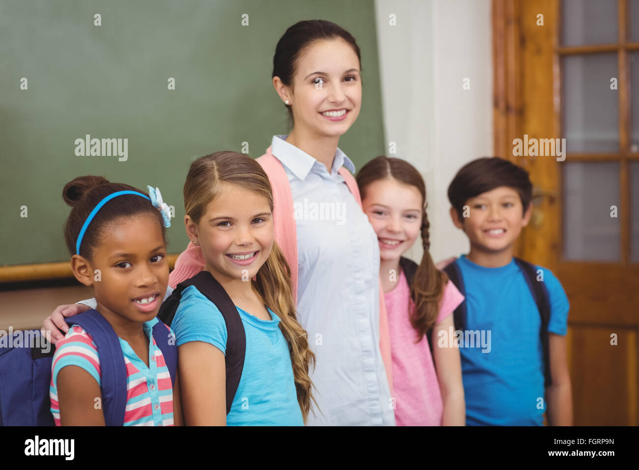 Teacher and pupils smiling in classroom Stock Photo - Alamy