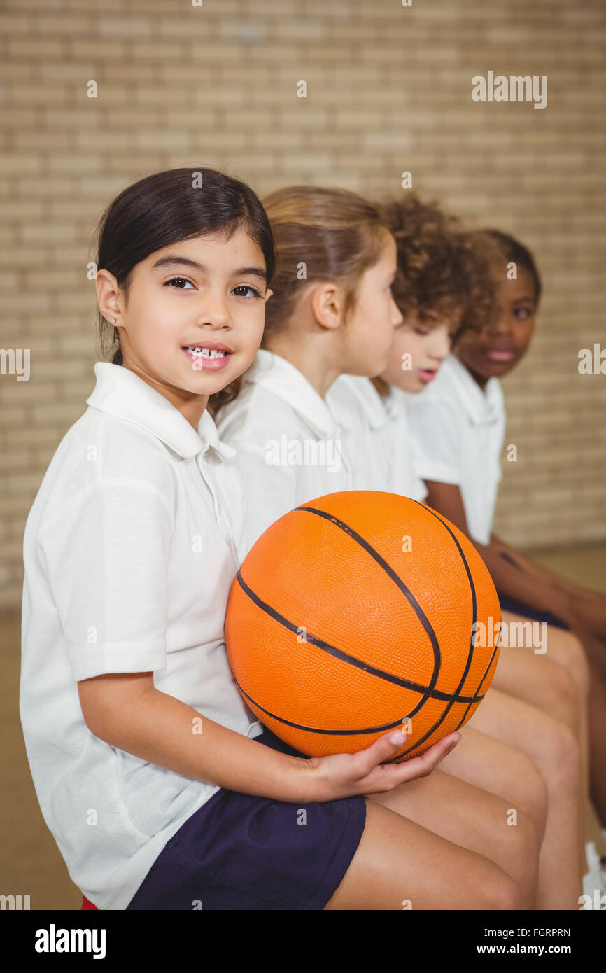Student holding basketball with fellow players Stock Photo