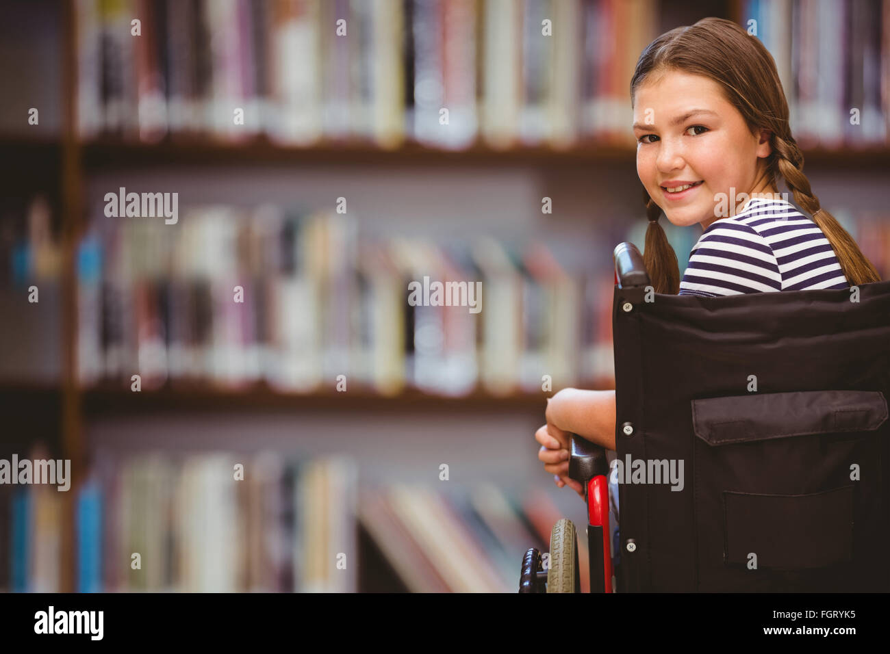 Composite image of girl sitting in wheelchair in school Stock Photo - Alamy