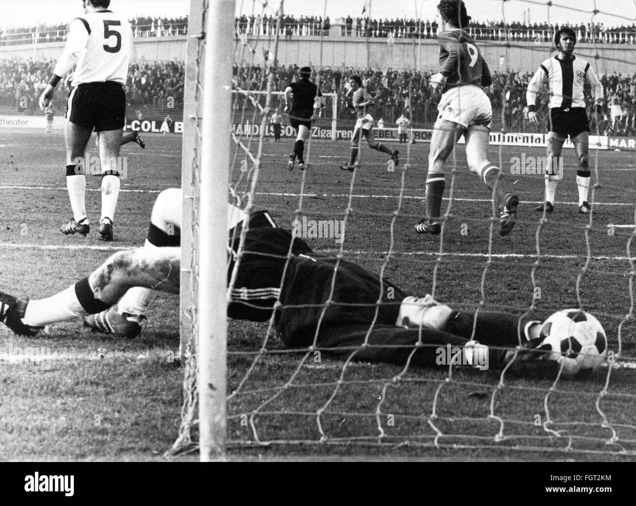sports,football,games,Germany,DFB-Pokal,1970 / 1971,second round,game FC Schalke 04 versus VfR Heilbronn(4:0),Glückaufkampfbahn,Gelsenkirchen,20.2.1971,goal for the 1:0 for Schalke by Rolf Ruessmann,goal keeper Karl-Heinz Seyffer lying on the ground,DFB cup,football match,soccer match,football matches,footballer,footballers,kicker,football player,football players,ball,nets,goal net,Karl Heinz,lying,hitting,hit,defeating,defeat,football stadium,soccer stadium,football stadiums,soccer stadiums,sports stadium,sports stadiums,G,Additional-Rights-Clearences-Not Available Stock Photo