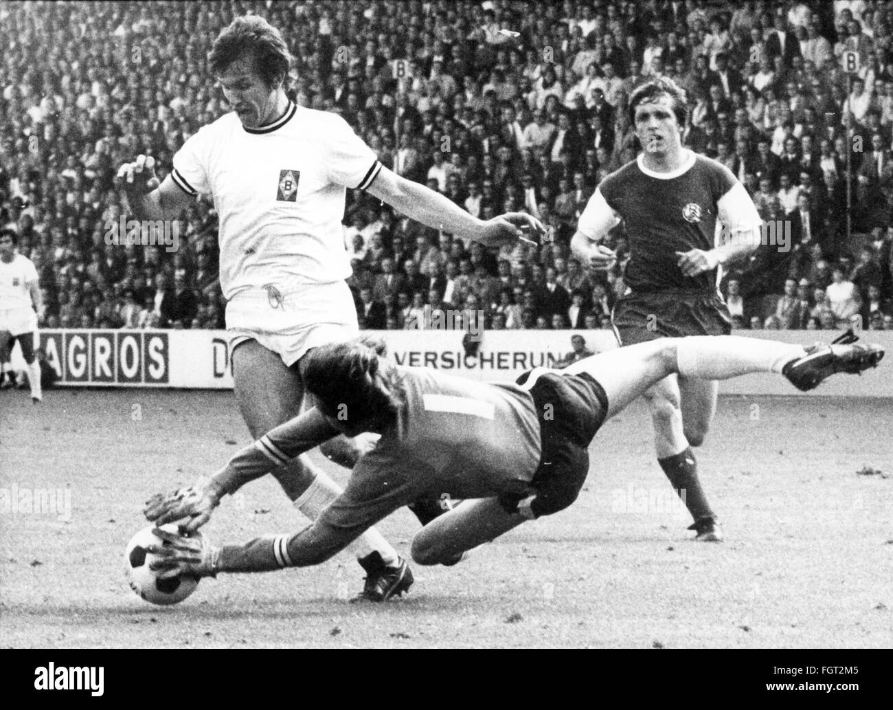 sports,football,games,Germany,national league,season 1970 / 1971,33rd match day,game Borussia Moenchengladbach versus Rot-Weiss Essen(4: 3),Boekelbergstadion,Moenchengladbach,29.5.1971,goal keeper Heinz Blasey(Essen)repelles the attack of striker Jupp Heynckes,behind defender Roland Peitsch,Rot Weiss,football match,soccer match,football matches,footballer,footballers,kicker,football player,football players,action,act,actions,acts,assaults,assault,attack,offensive move,attacks,offensive moves,defences,defenses,defense,defenc,Additional-Rights-Clearences-Not Available Stock Photo