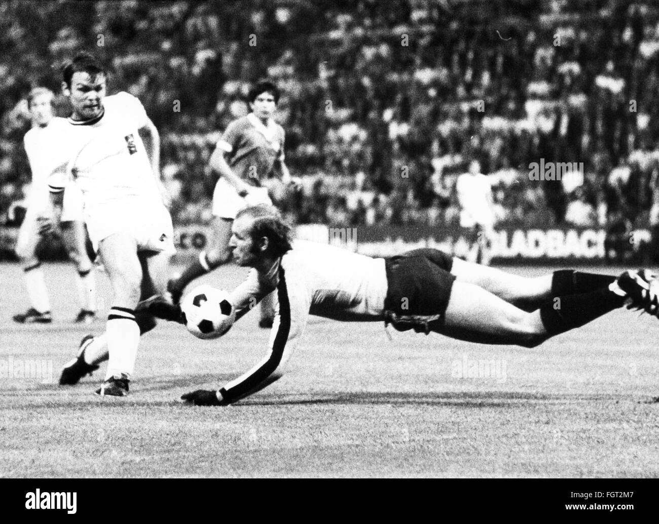sports,football,games,Germany,DFB-Pokal 1969 / 1970,quarter final,game Borussia Moenchengladbach versus 1. FC Koeln(2:3),Boekelbergstadion,Gelsenkirchen,5.8.1970,goal keeper Manfred Manglitz(Cologne repelling the attack of striker Herbert Laumen,DFB cup,football match,soccer match,football matches,footballer,footballers,kicker,football player,football players,action,act,actions,acts,attack,offensive move,attacks,offensive moves,defences,defenses,defense,defence,save,military parade,running,run,runs,jumping,jumps,jump,pl,Additional-Rights-Clearences-Not Available Stock Photo