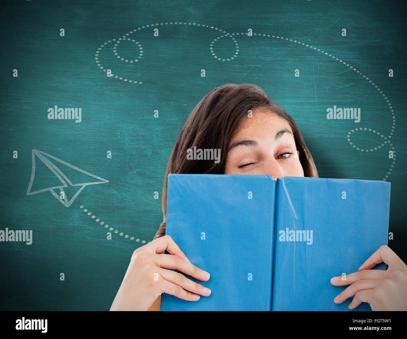 Composite image of portrait of a student winking behind a blue book ...