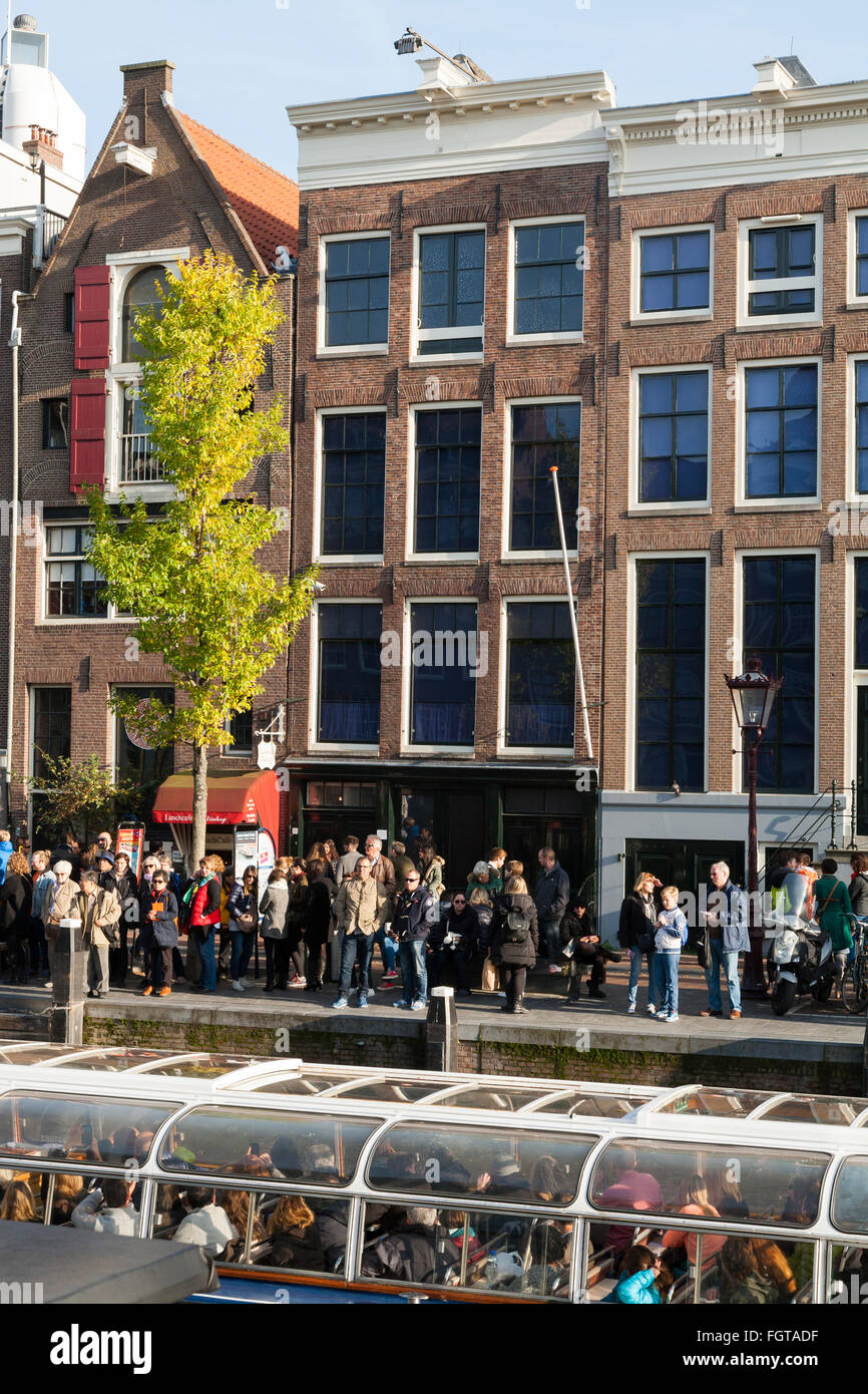 Tourist sight seeing boat with tourists / visitors in front of Anne Frank 's House / museum in Amsterdam Holland The Netherlands Stock Photo