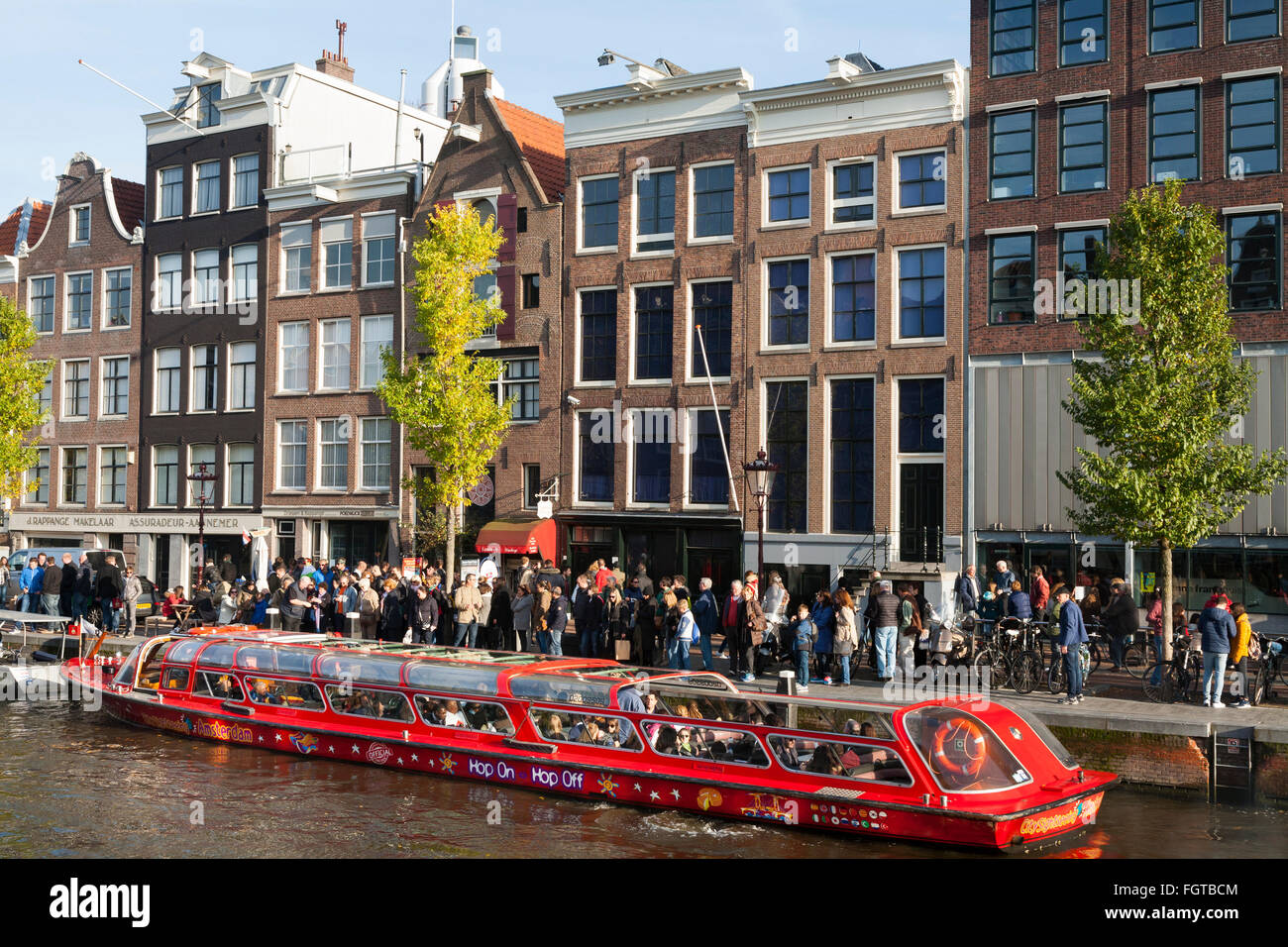 Tourist sight seeing boat with tourists / visitors in front of Anne Frank 's House / museum in Amsterdam Holland The Netherlands Stock Photo