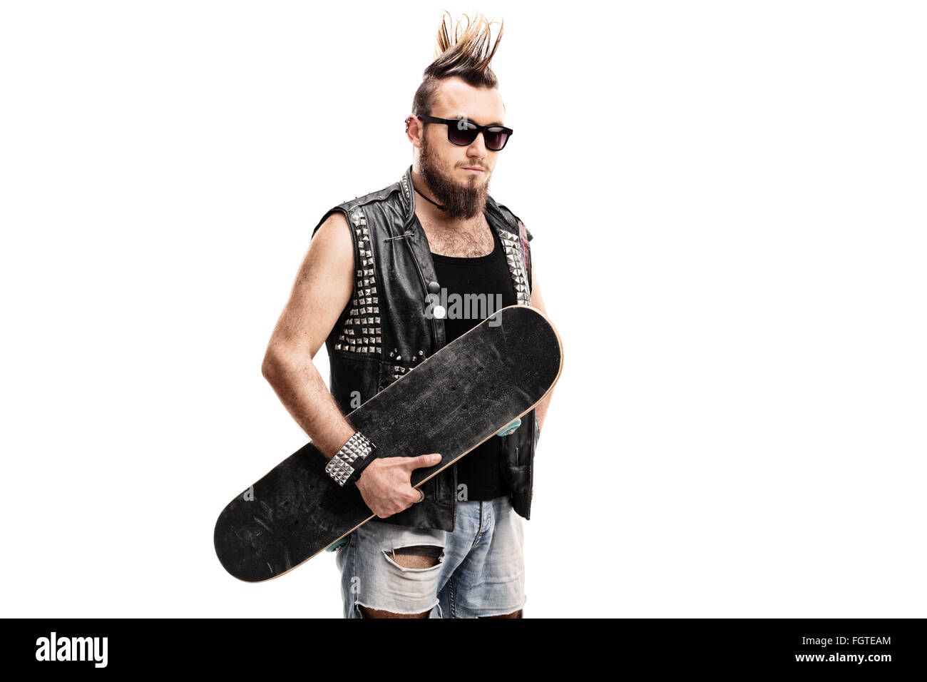 Punk rocker holding a skateboard and looking at the camera isolated on white background Stock Photo
