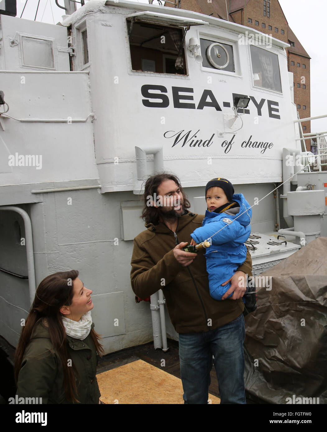 Rostock, Germany. 22nd Feb, 2016. Michael Buschheuer (C), founder of the refugee initiative 'Sea Eye, ' poses with his partner Hannelore Korduan (L) and his son Michael on deck of a cutte of the initiative following its christening in Rostock, Germany, 22 February 2016. After its christening, the cutter is to head to the Mediterranean Sea to rescue refugees in distress. Credit:  dpa picture alliance/Alamy Live News Stock Photo