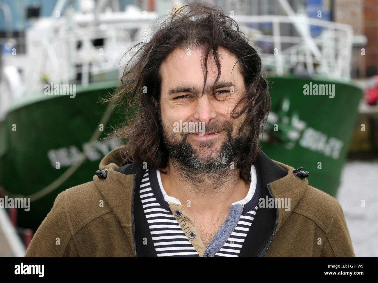 Rostock, Germany. 22nd Feb, 2016. Michael Buschheuer, founder of the refugee initiative 'Sea Eye, ' poses in front of a cutter of the initiative, in Rostock, Germany, 22 February 2016. After its christening, the cutter is to head to the Mediterranean Sea to rescue refugees in distress. Credit:  dpa picture alliance/Alamy Live News Stock Photo