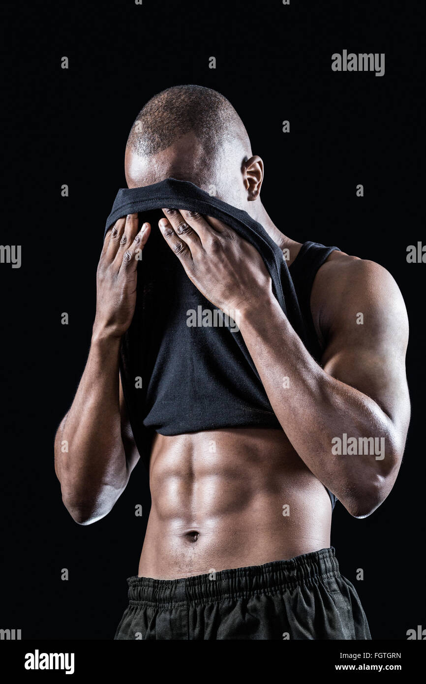 Muscular man wiping sweat with tank top Stock Photo - Alamy