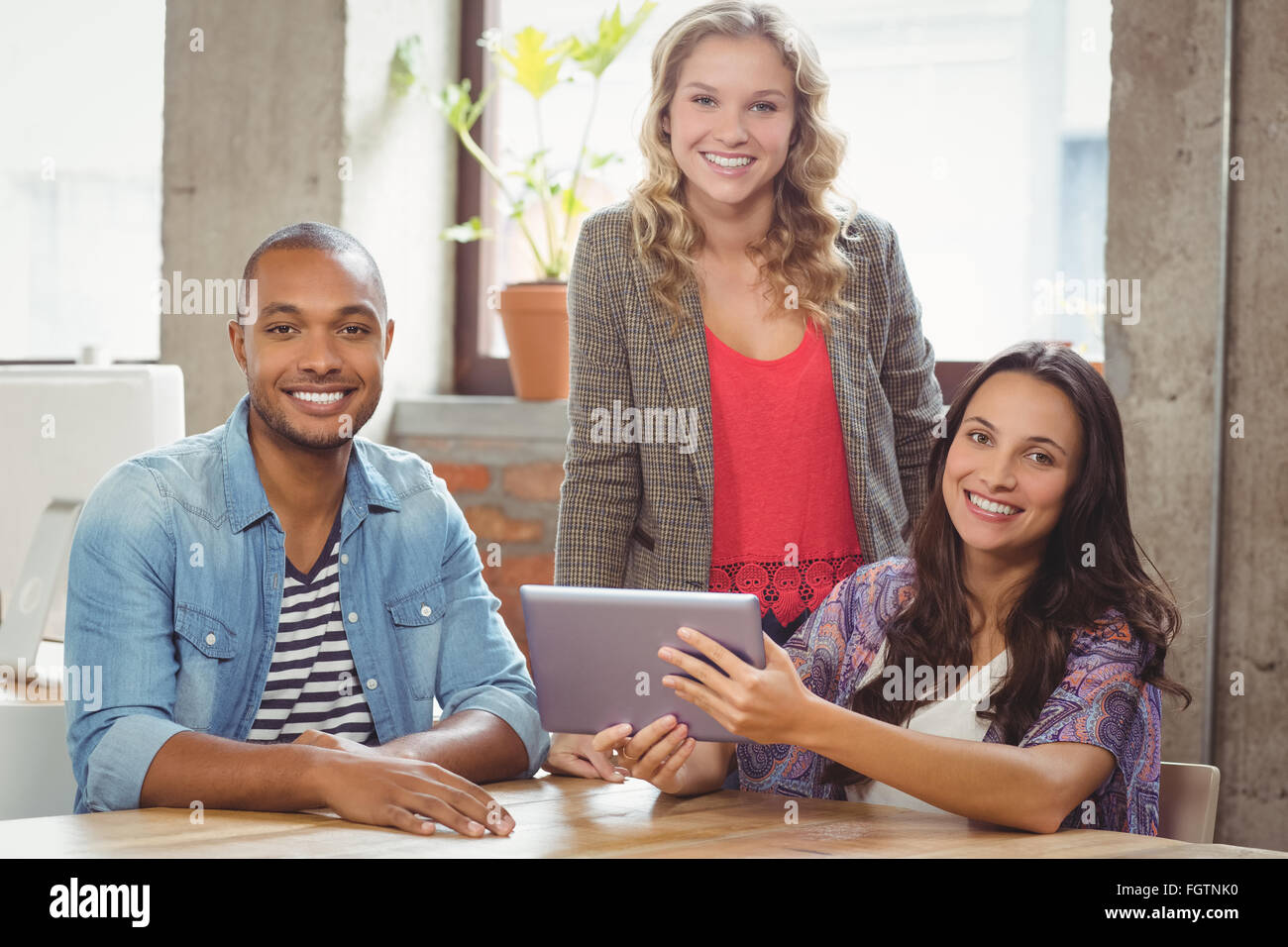 Portrait of smiling business people discussing over tablet Stock Photo ...
