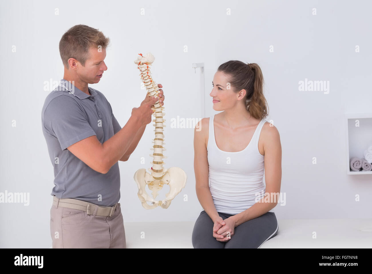 Doctor showing anatomical spine to his patient Stock Photo
