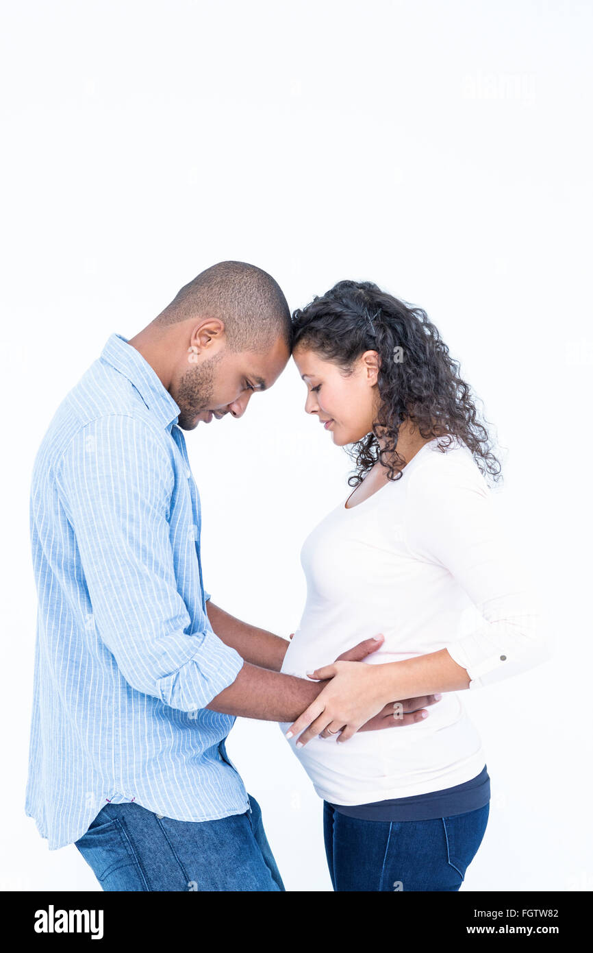 Man looking at pregnant belly against white background Stock Photo - Alamy