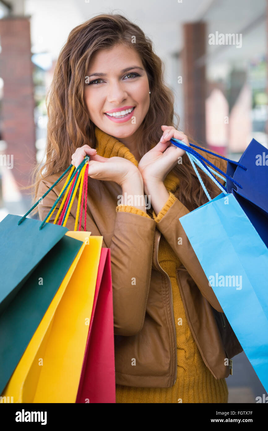 Portrait of smiling woman with shopping bags looking at camera Stock ...