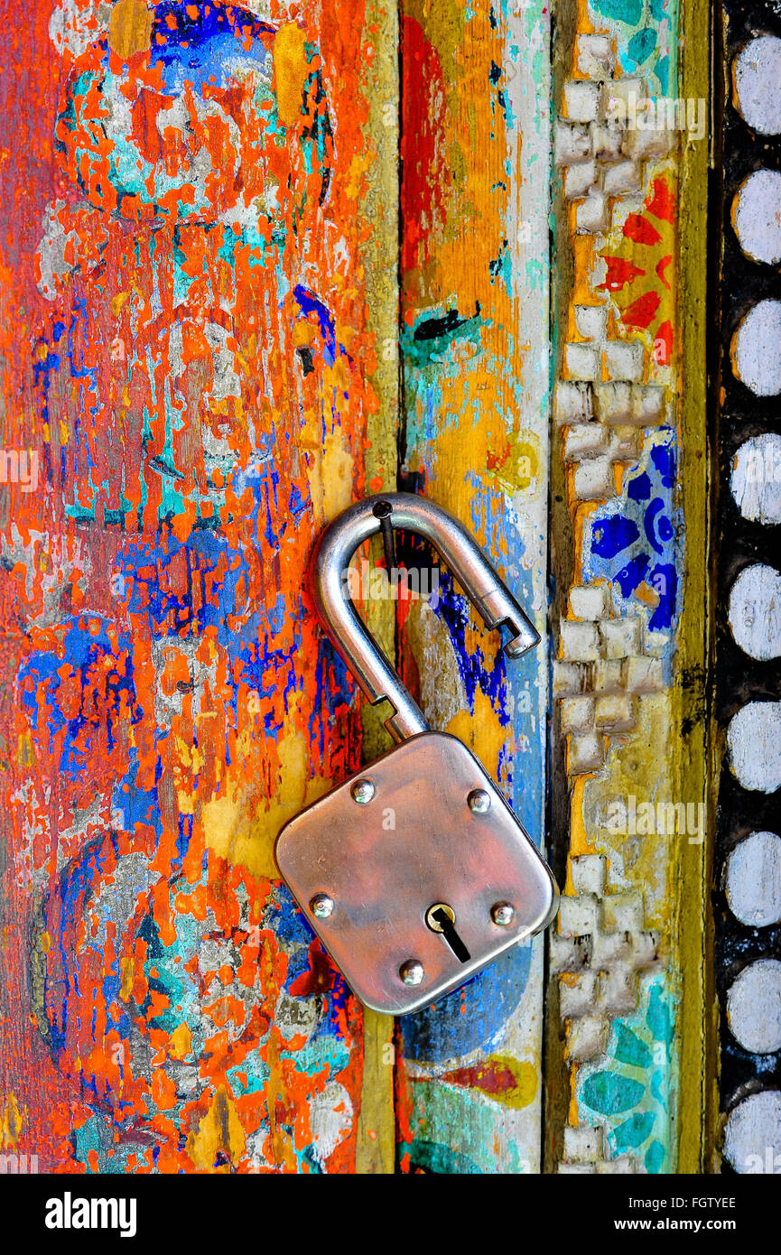 An unlocked lock hanging on the colorful wall of Buddhist monastary in Ladakh Stock Photo
