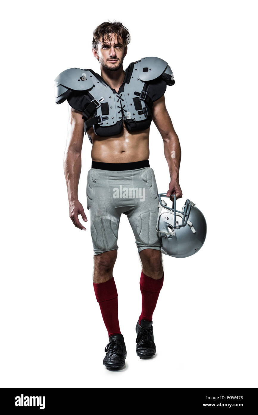 Shirtless American football player with padding holding helmet Stock