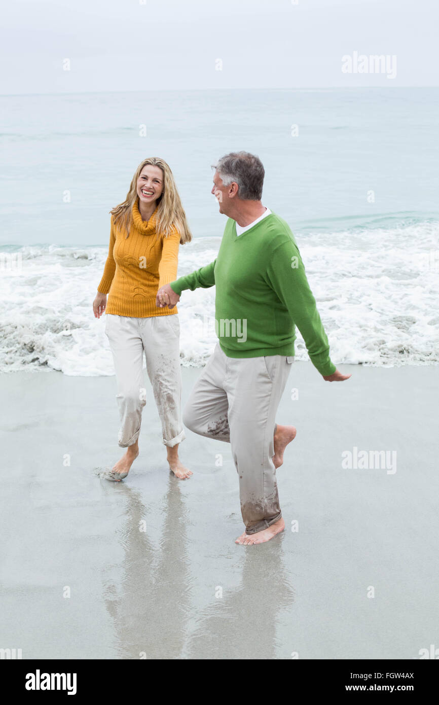 Happy couple holding hands and running Stock Photo - Alamy