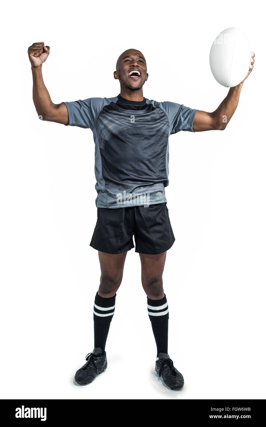 Cheerful sportsman with clenched fist holding rugby ball Stock Photo