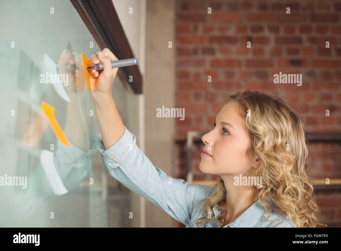Creative businesswoman writing on sticky notes in office Stock Photo ...