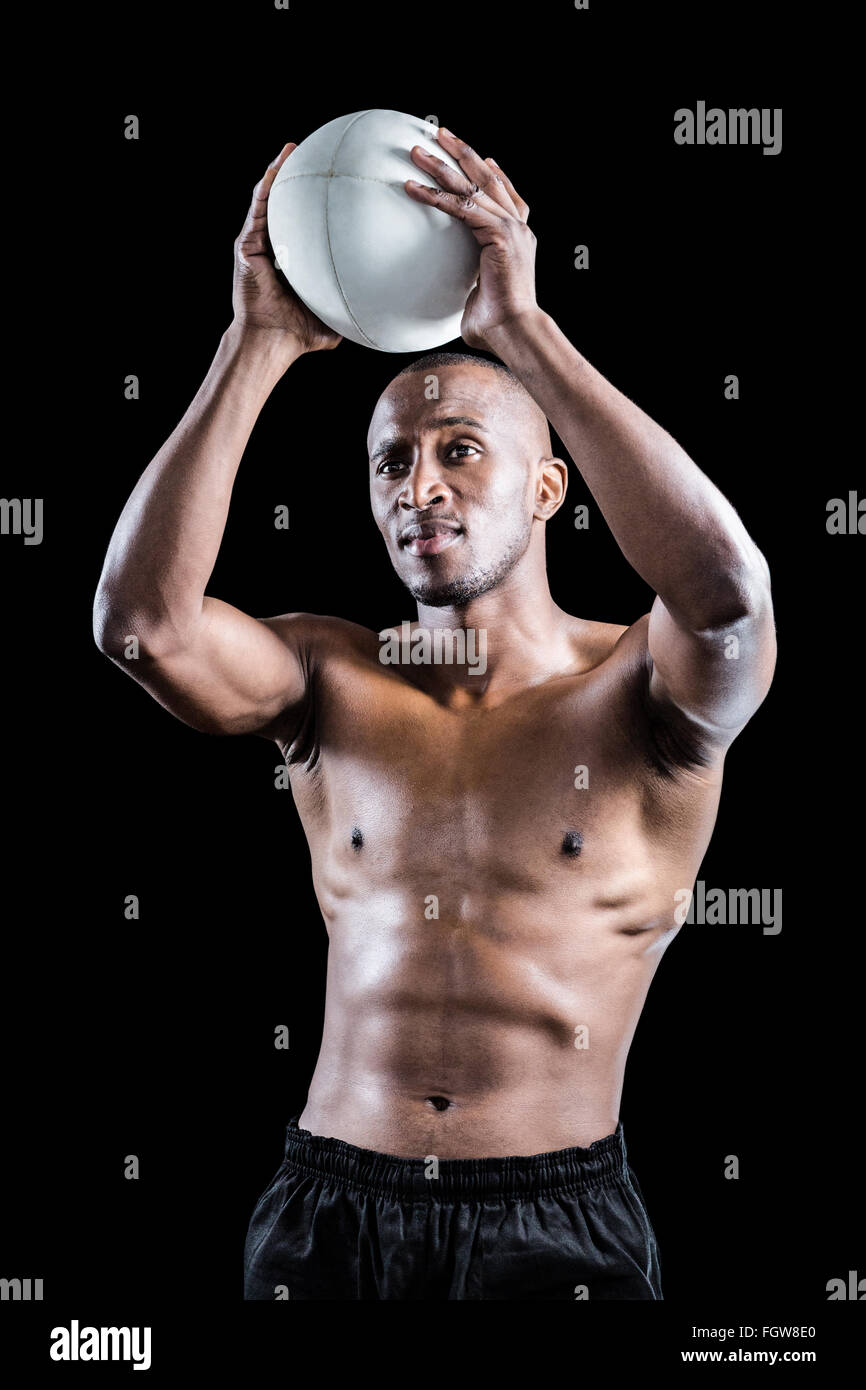 Shirtless athlete throwing rugby ball Stock Photo Alamy