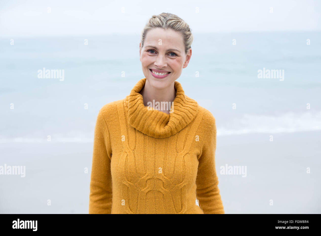 Smiling woman standing in front of the sea Stock Photo - Alamy