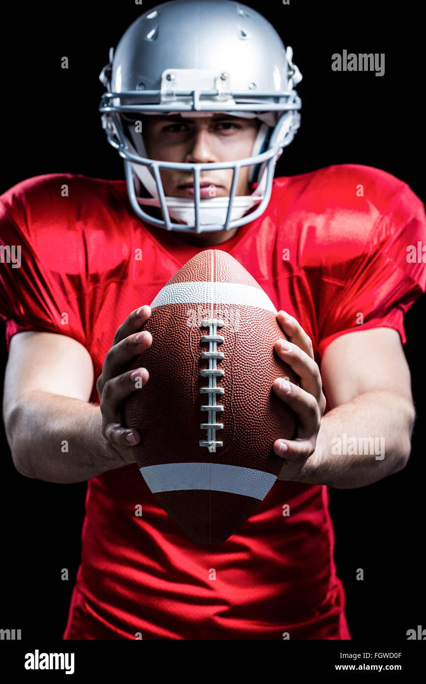 Portrait of American football player holding ball Stock Photo - Alamy