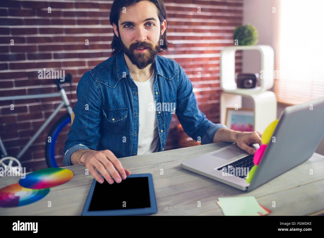 Portrait of businessman using graphic tablet and laptop Stock Photo - Alamy