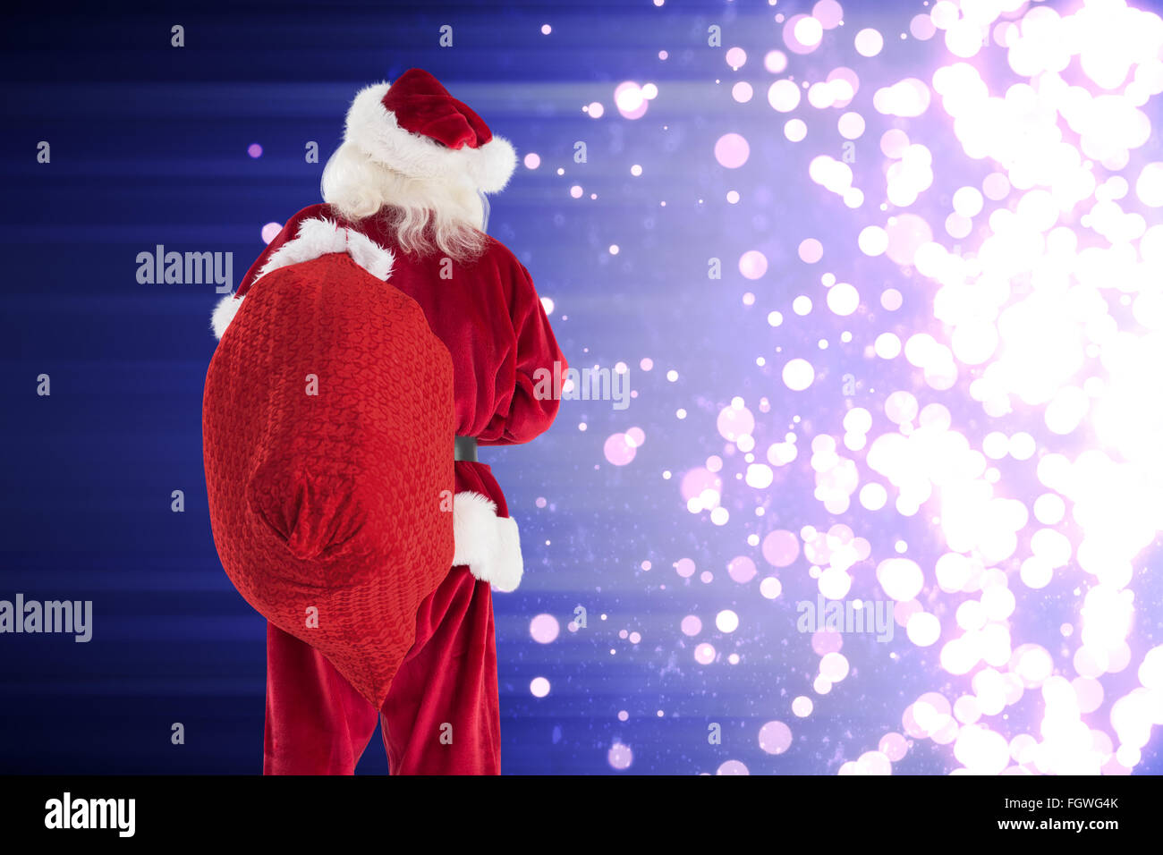 Composite image of santa is holding his bag in one hand Stock Photo - Alamy