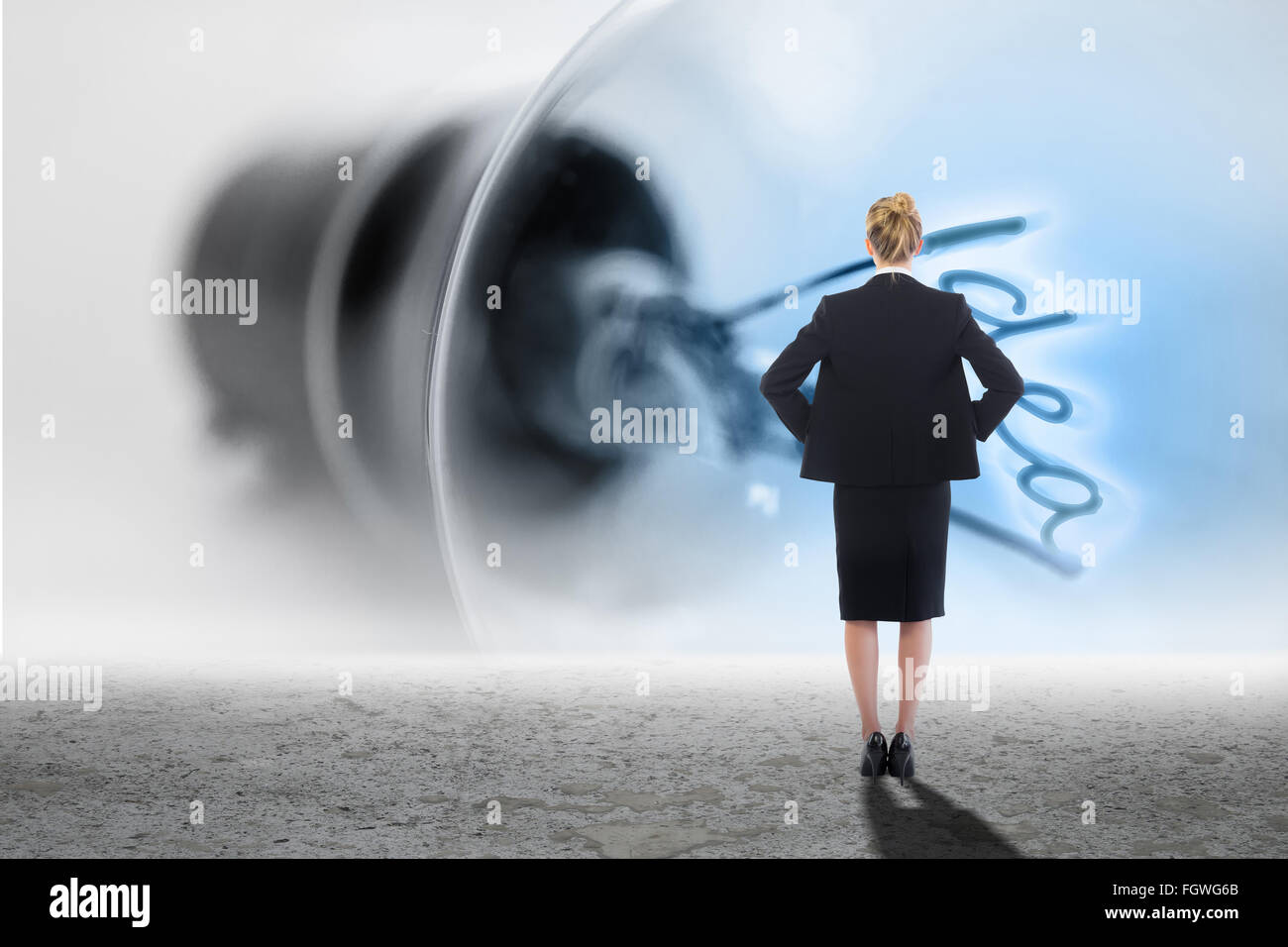 Composite image of businesswoman standing with hands on hips Stock Photo