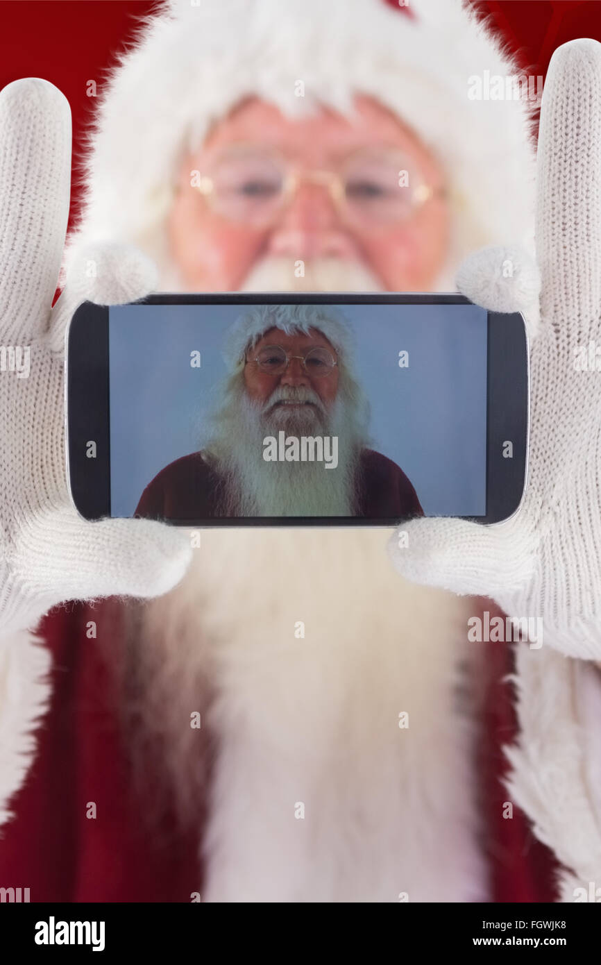 Composite image of santa records himself with a smartphone Stock Photo ...