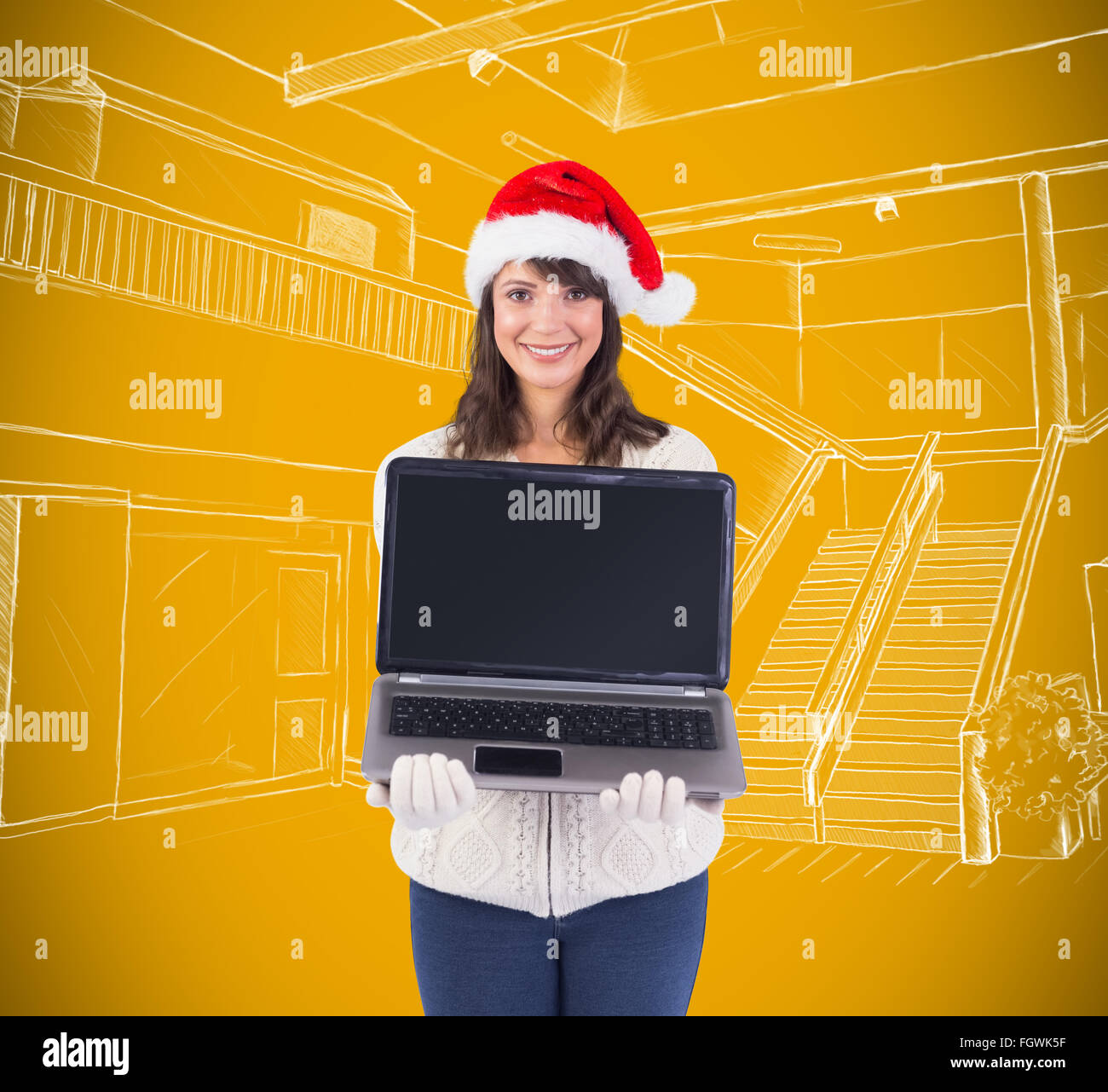 Composite image of smiling brunette in santa hat showing her laptop Stock Photo