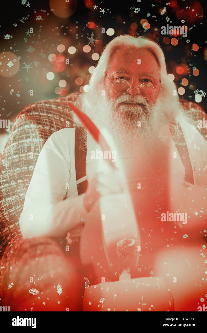 Composite image of happy santa writing list on the armchair Stock Photo ...