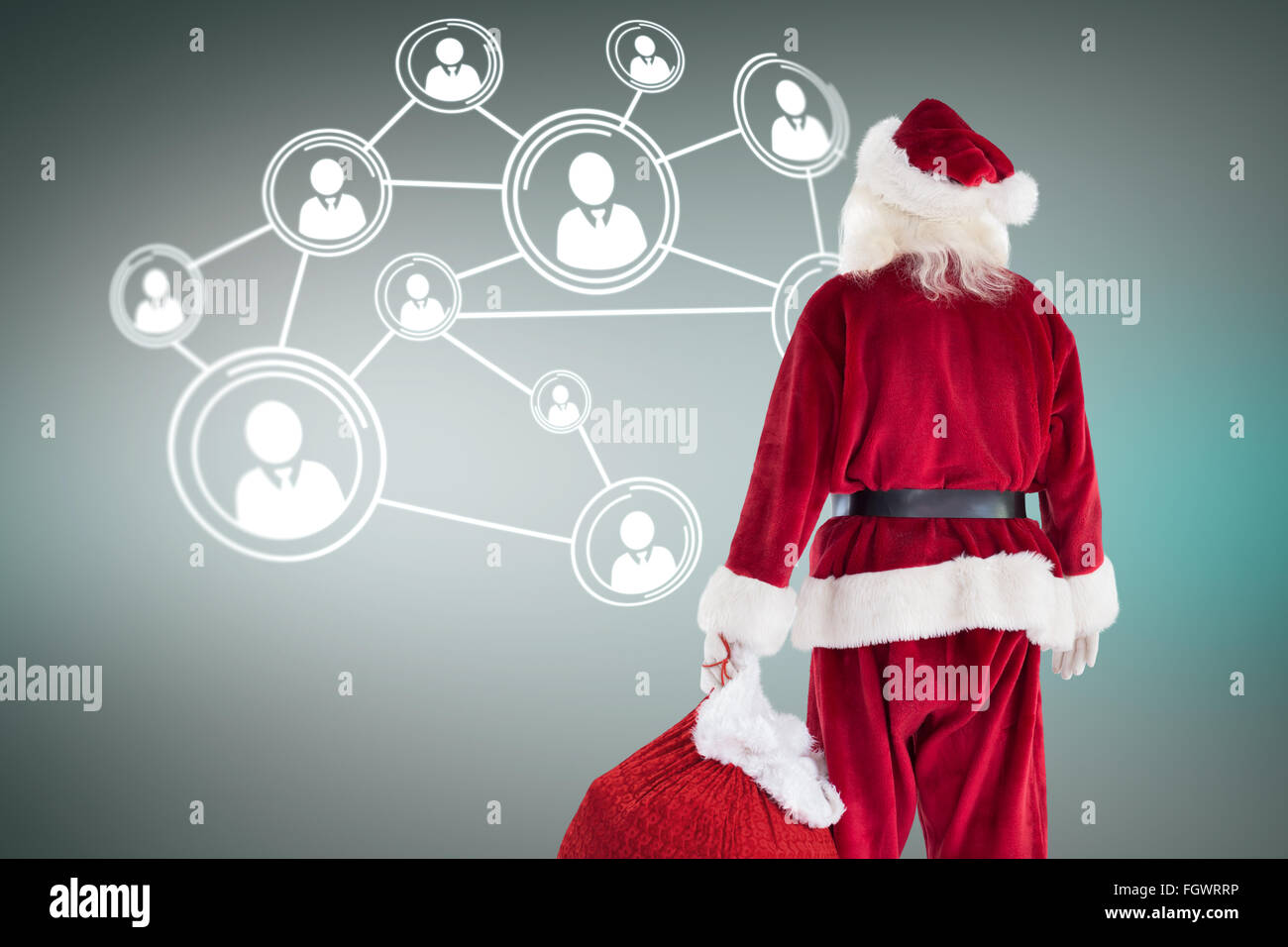 Composite image of santa carrying sack of gifts Stock Photo - Alamy