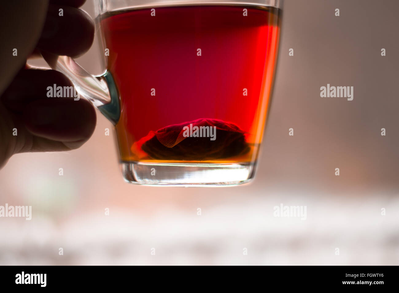 Cup of black tea, with intense focus of teabag on the bottom of the glass. Stock Photo