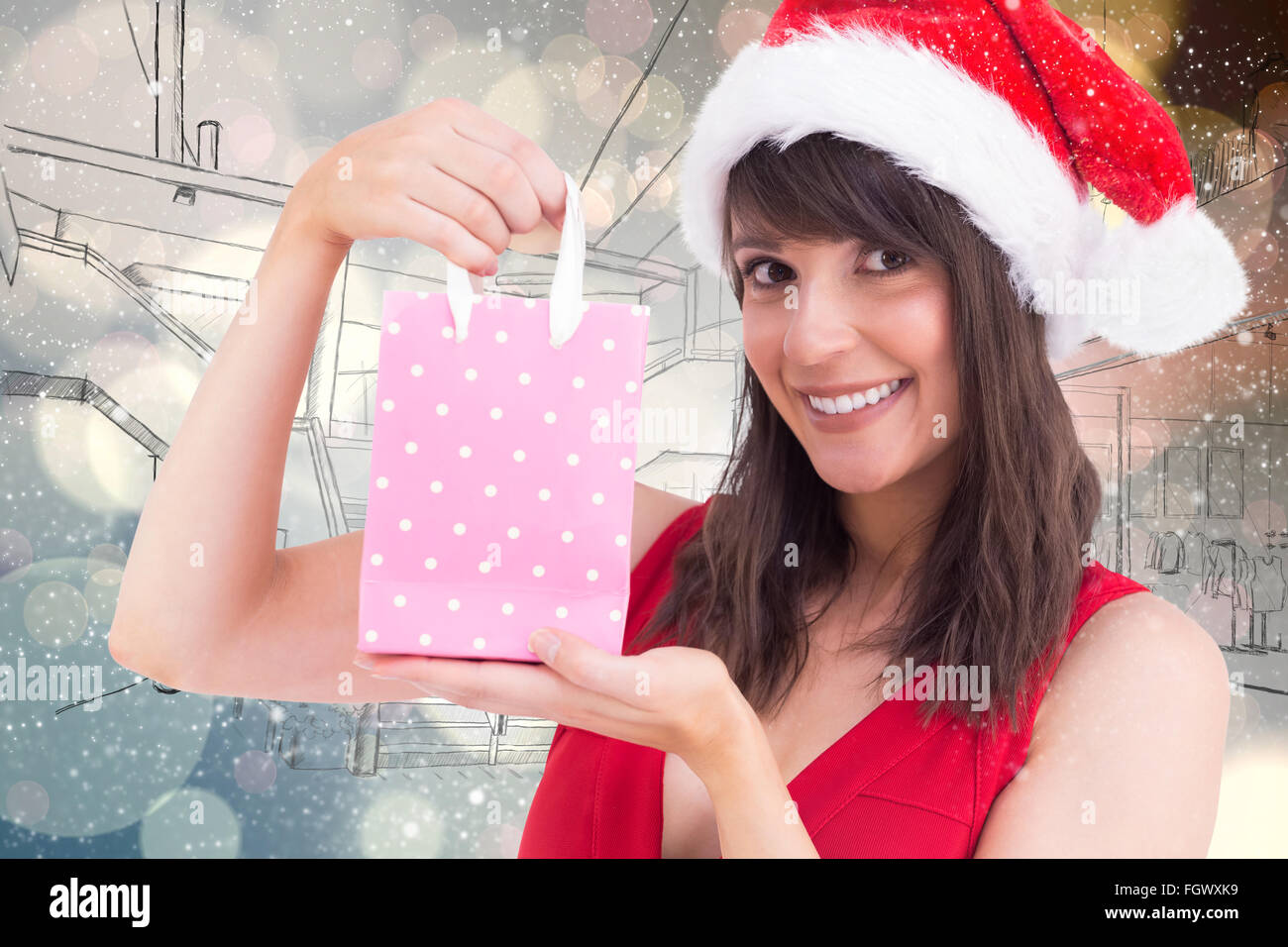 Composite image of festive brunette holding a gift bag Stock Photo