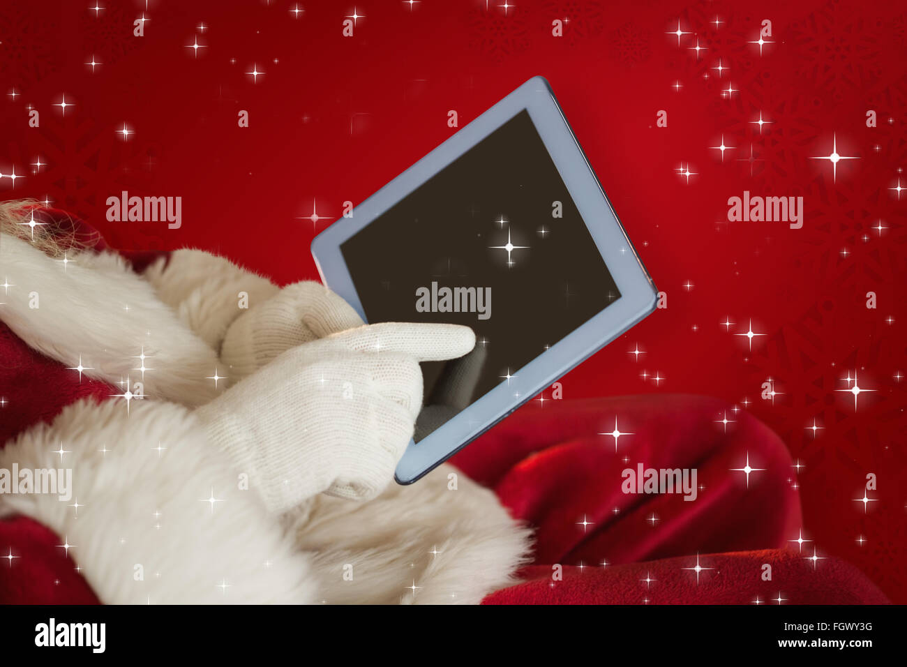 Composite image of santa using tablet on the armchair Stock Photo - Alamy