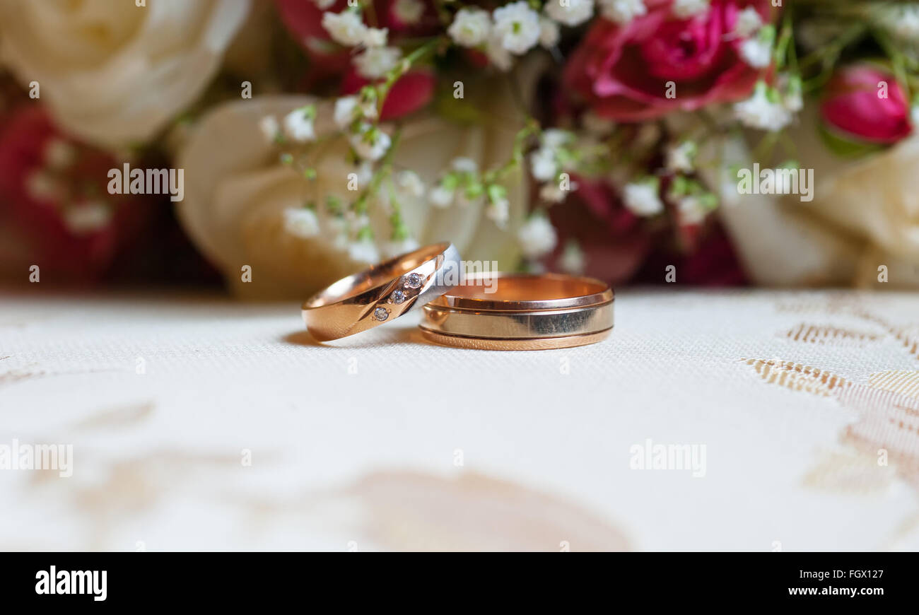 Wedding gold rings on a background of red roses Stock Photo