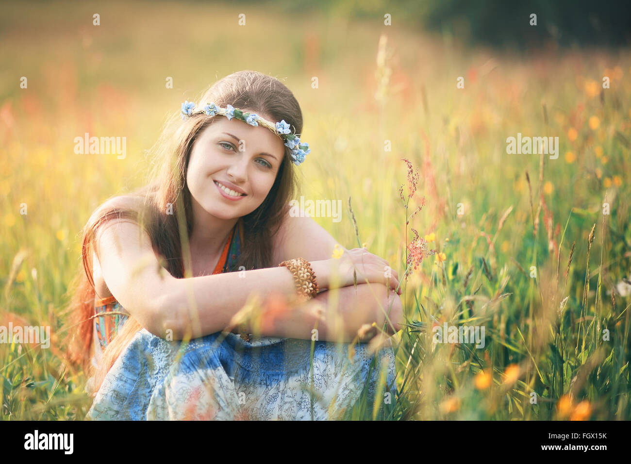 Smiling romantic woman in flower field . Hippie and gypsy dress Stock Photo