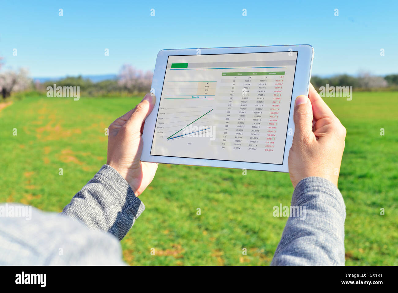 closeup of a young farmer observing some charts in a tablet computer in a fallow field Stock Photo