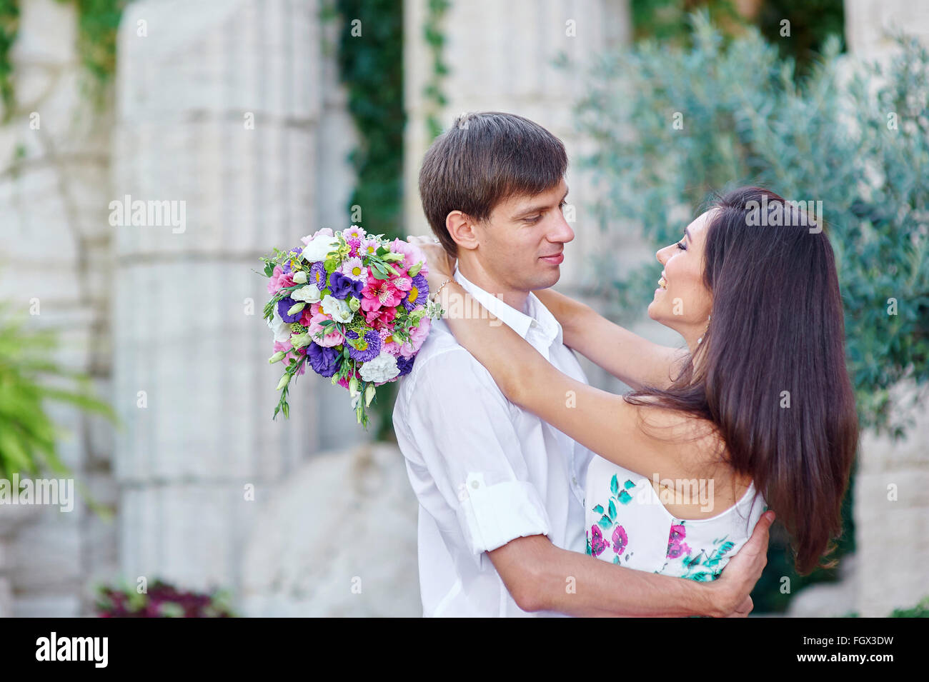 happy bride and groom walking among the columns Stock Photo